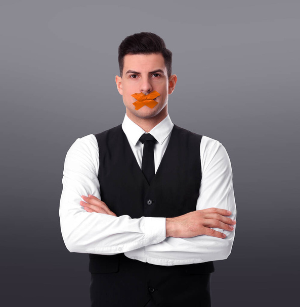Man with taped mouth on grey background. Speech censorship - 写真・画像
