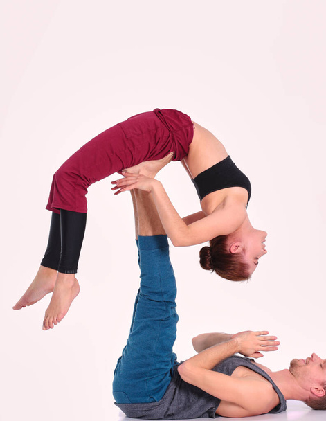 Young athletic couple practicing acroyoga. Balancing in pair - Фото, зображення