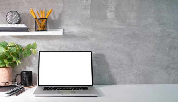 Laptop computer, house plant and supplies on white table. Blank screen and copy space for your advertise text. - 写真・画像