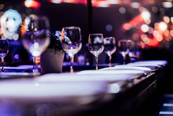 Luxury table settings for fine dining with and glassware, pouring wine to glass. Beautiful blurred background. Preparation for holiday wedding. Fancy luxury restaurant. - Foto, immagini