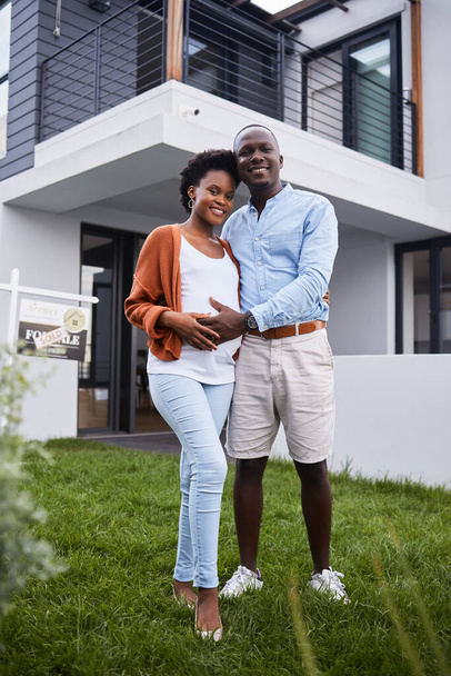 First-time homeowners and parents. Portrait of a young couple standing outside their new home - Photo, image