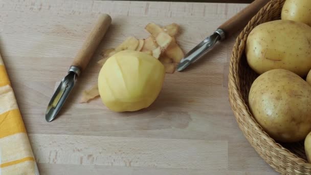 生のジャガイモとテーブルの上の野菜皮むき器 - 映像、動画