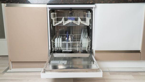 Open dishwasher loaded with half utensils - Photo, Image