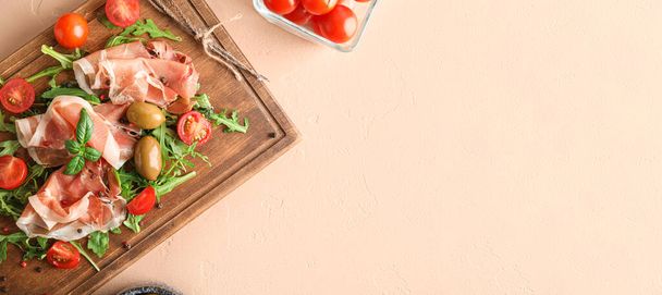 Houten bord met heerlijke jamon, specerijen, olijven en tomaten op lichte ondergrond met ruimte voor tekst - Foto, afbeelding