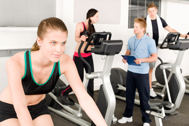 Young fitness woman doing spinning with instructor - Foto, imagen
