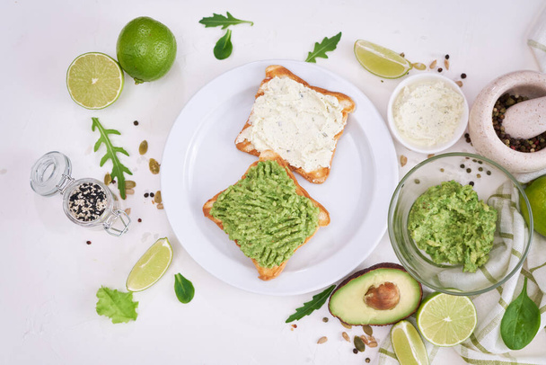 avocado and cream cheese toasts on a plate and ingredients. - Foto, Imagen