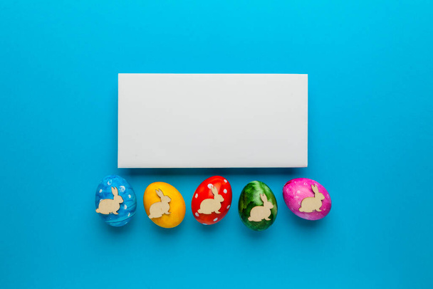 Bright easter eggs with bunny (rabbit) on blue background. Retro colorful spring decoration. Copy space for text. - Fotó, kép