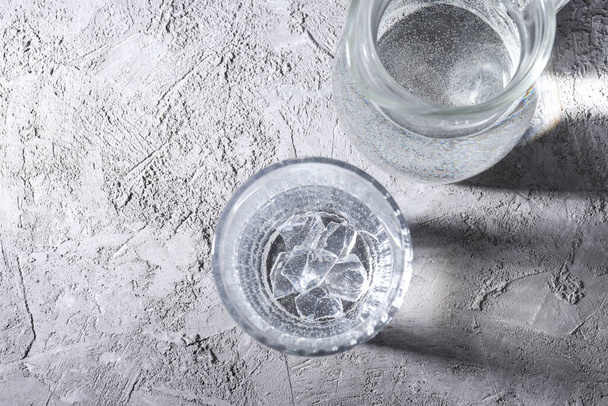 Jug and glass of water on gray textured background - Zdjęcie, obraz