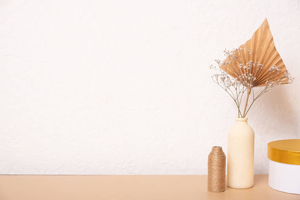 Empty table and vases of dried grass and palm leaves on white background, interior, home design. Blank table for your designs. - 写真・画像