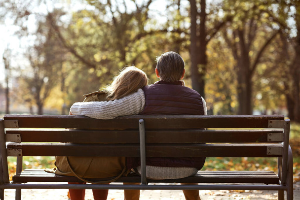 Senior caucasian couple sitting at the bench in park  - Photo, Image