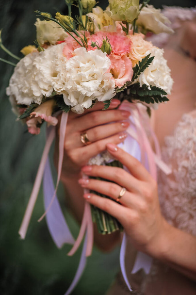 beautiful wedding bouquet on a blurred background of a bride - Фото, зображення