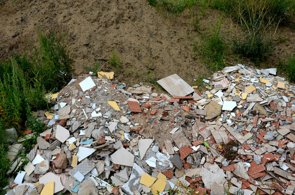 piles of waste, tiles and rubble from the construction illegally dumped from a truck into nature, into a meadow. it spoils the environment and the expensive costs of cleaning and recycling - Fotó, kép