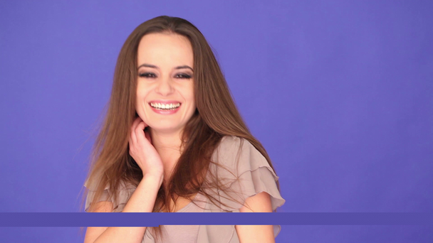Hezká žena s úsměvem na fialová - Záběry, video