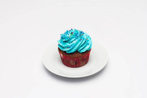 Cupcake with butter cream icing on the saucer. - Foto, Imagen