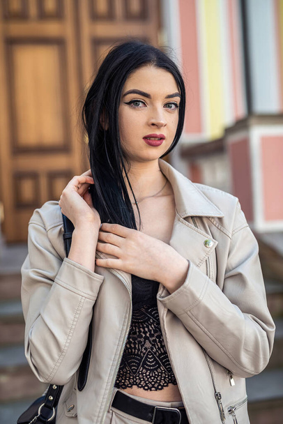 Young prety woman wear fashion white cloth pose outdoor against a old house in city - Fotografie, Obrázek