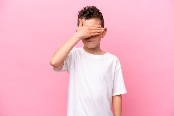 Little caucasian boy isolated on pink background covering eyes by hands. Do not want to see something - Valokuva, kuva