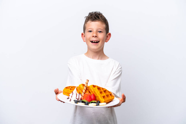 Little caucasian boy holding a waffles isolated on white background - Foto, Imagen