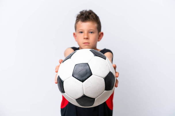 Chłopiec gra w piłkę nożną nad odizolowaną białą ścianą - Zdjęcie, obraz