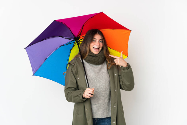 Young caucasian woman holding an umbrella isolated on white background giving a thumbs up gesture - Fotografie, Obrázek