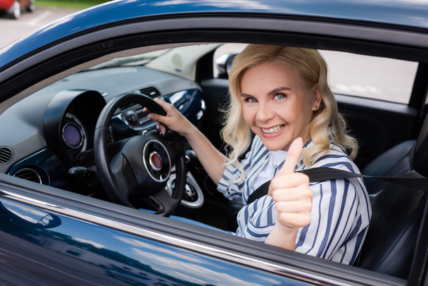 Positive driver showing like gesture during driving course in car  - Zdjęcie, obraz