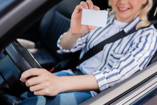 Cropped view of blurred woman holding driving license in car  - Foto, Imagen