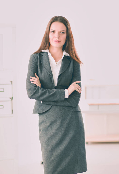 Portrait of business woman standing with crossed arms in office - 写真・画像