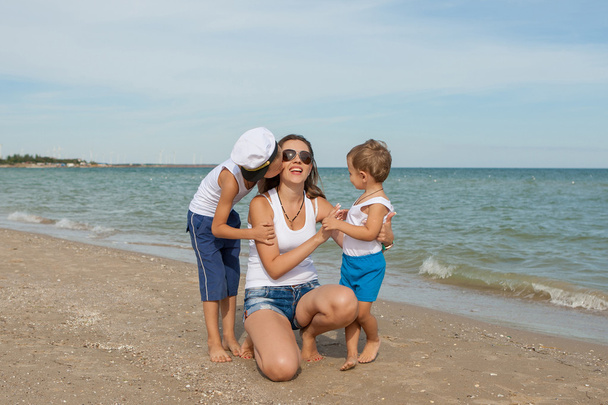 Mutter und ihre beiden Söhne amüsieren sich am Strand - Foto, Bild