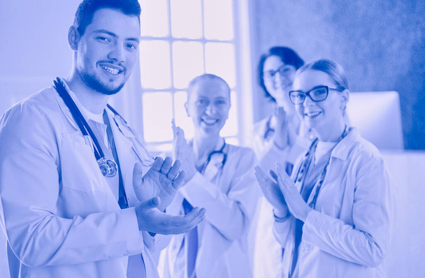 Happy medical team comprising male and female doctors smiling broadly and giving a thumbs up of success and hope. - Foto, Bild