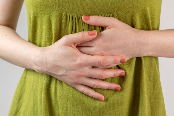 Female hands on stomach. Stomach ache concept. - Фото, изображение