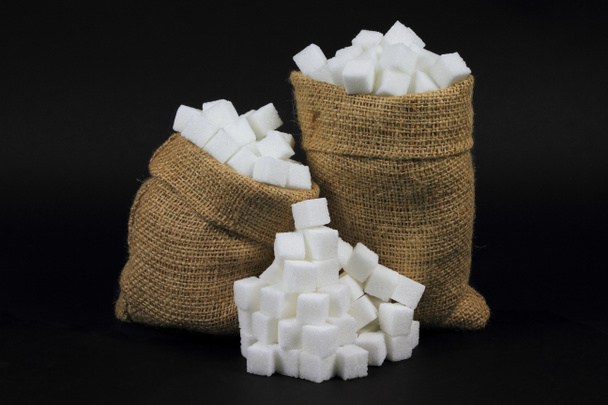 Zucchero a cubetti in sacchetti di iuta nero
. - Foto, immagini