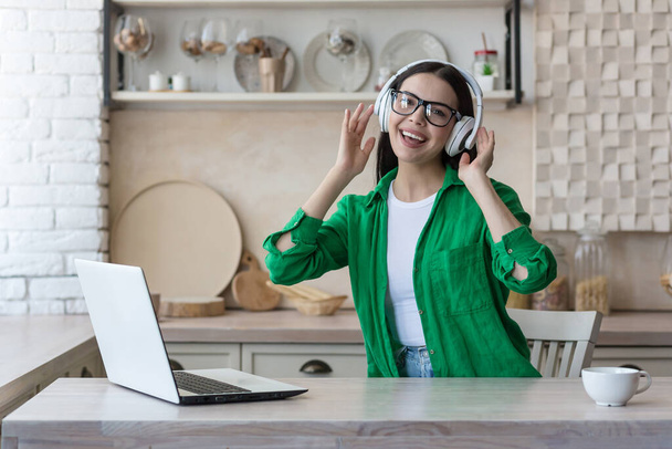 attractive young woman working with laptop and listening music at home - 写真・画像