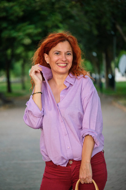 Outdoor portrait of smiling mature redhead woman. Middle aged woman. - Foto, Imagen