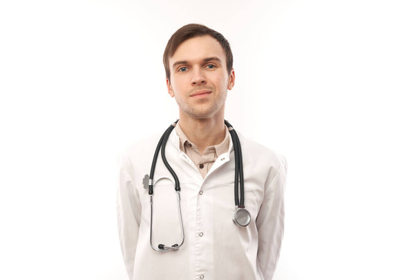 Portrait of handsome doctor in white medical coat with stethoscope on white background with copy space - Фото, зображення