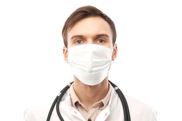Portrait of doctor in white medical coat and protective face mask isolated on white background with copy space - Φωτογραφία, εικόνα