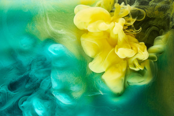 Liquid fluid art abstract background. Green, yellow dancing acrylic paints underwater, space smoke ocean, color explosion - Foto, imagen