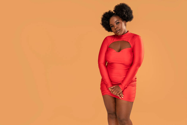 Beautiful african Woman posing in red mini dress, looking at the camera. Afro hairstyle, glamour makeup. Studio Background. Fashionable girl. A lot of copy space - Foto, Imagem