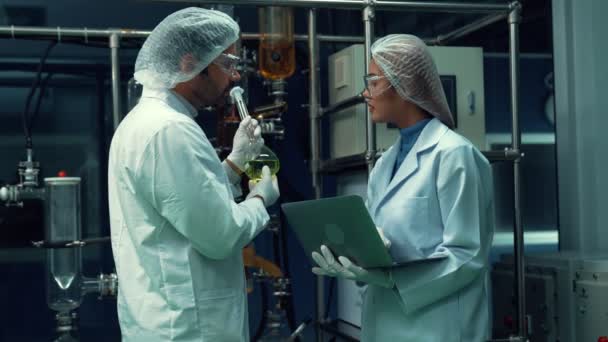 Two scientist in professional uniform working in curative laboratory for chemical and biomedical experiment - Кадры, видео