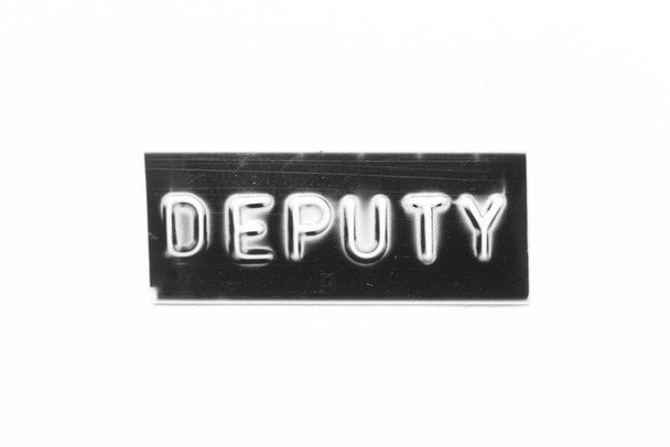 Black color banner that have embossed letter with word deputy on white paper background - Fotó, kép