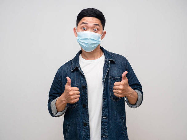 Positive man jeans shirt wearing medical mask show double thumb up isolated - Fotografie, Obrázek