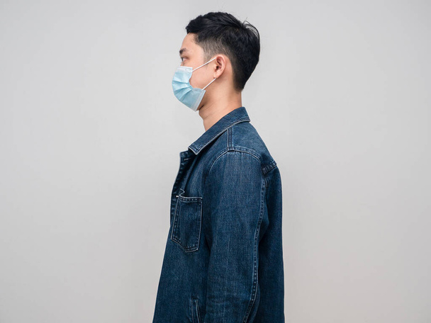 Side view young man jeans shirt wear medical mask isolated - Foto, immagini