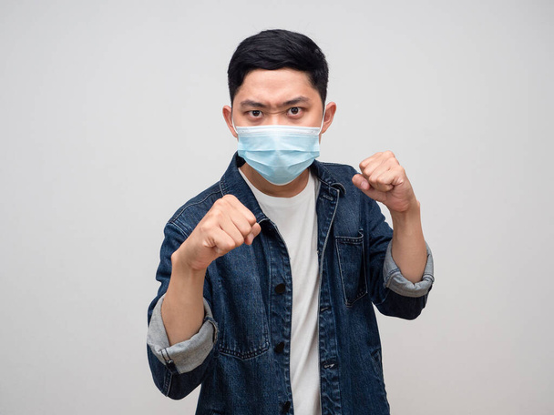 Man jeans shirt wear medical mask gesture punching for fighting with epidemic isolated - Foto, Bild