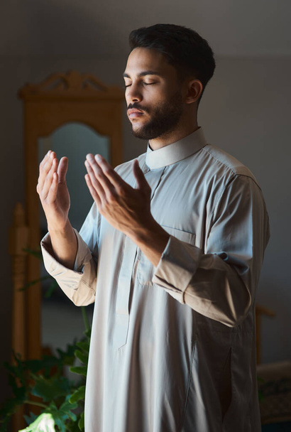 Prayer enlarges the heart. a young muslim man praying in the lounge at home - Fotoğraf, Görsel