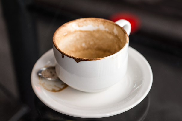 Tazza da caffè vuota usata con macchie sul tavolo di vetro
    - Foto, immagini