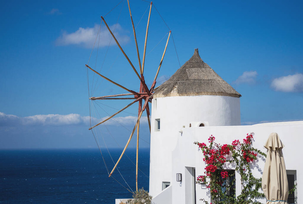 Old traditional whitewashed greek windmill on Santorini island in Oia town with stairs in street. Greece. - Foto, afbeelding