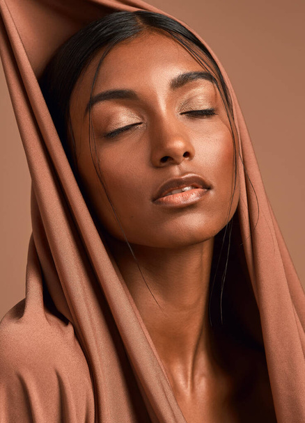 Who wouldnt be the one she loved. an attractive young woman wearing a head scarf against a brown background - Фото, изображение