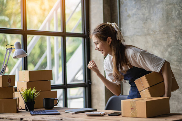 Portrait of a small business startup, SME owner, young Asian entrepreneur, working, unboxing, checking orders online. To prepare to pack parcel delivery boxes for sale to SME customers online business ideas - Fotoğraf, Görsel
