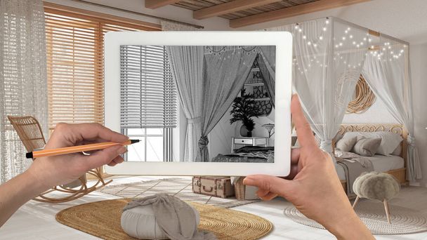 Hands holding and drawing on tablet showing bohemian bedroom, canopy bed in boho style details CAD sketch. Real finished interior in the background, architecture design presentation - Zdjęcie, obraz
