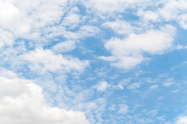 Beautiful white fluffy clouds in blue sky. Nature background from white clouds in sunny day. - Фото, изображение