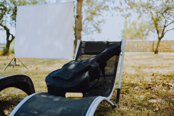 Home theater in the garden, guitar on a lounger, summer vacation photo - Zdjęcie, obraz