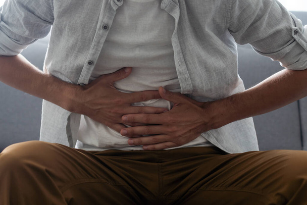 man having a stomach ache. Problems and health care concepts. - Foto, afbeelding